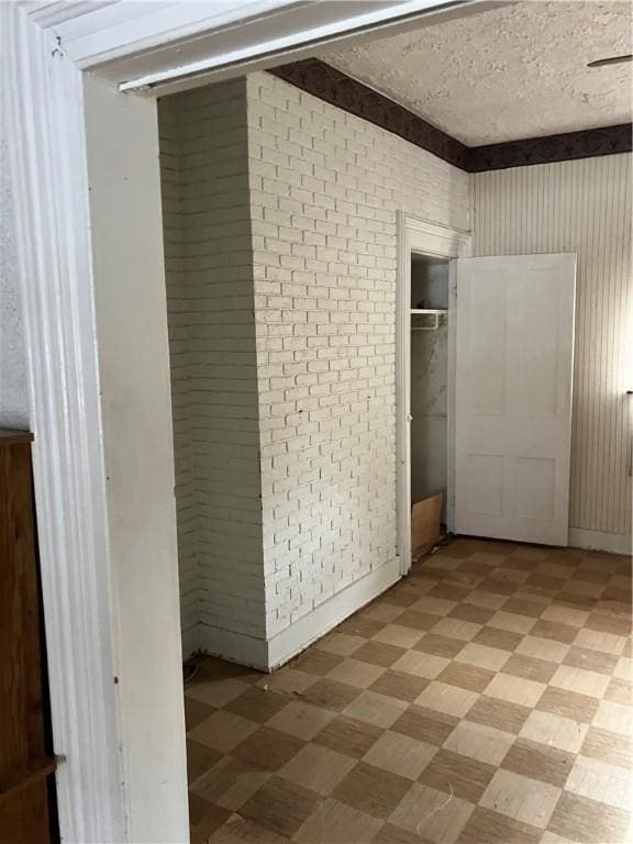 unfurnished bedroom featuring brick wall