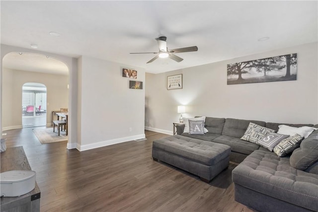 living room featuring ceiling fan and dark hardwood / wood-style flooring