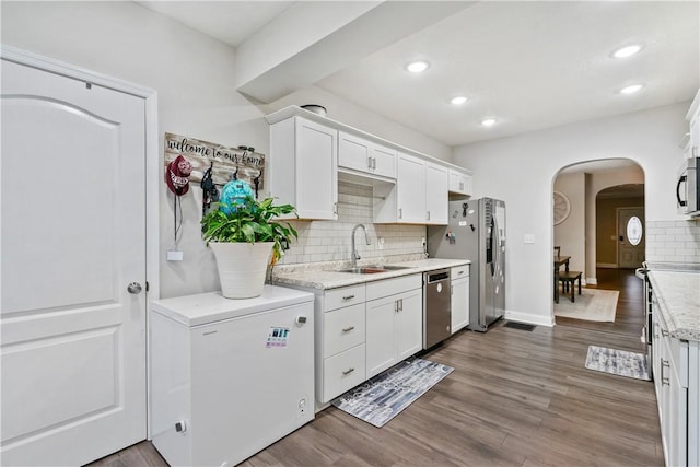 kitchen with dark hardwood / wood-style flooring, white cabinetry, sink, and stainless steel appliances