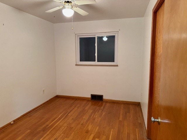 empty room with ceiling fan and light hardwood / wood-style flooring