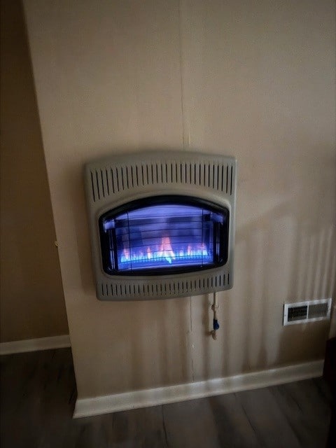 interior details with heating unit and hardwood / wood-style floors