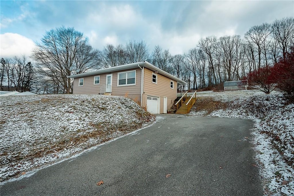 view of snowy exterior featuring a garage