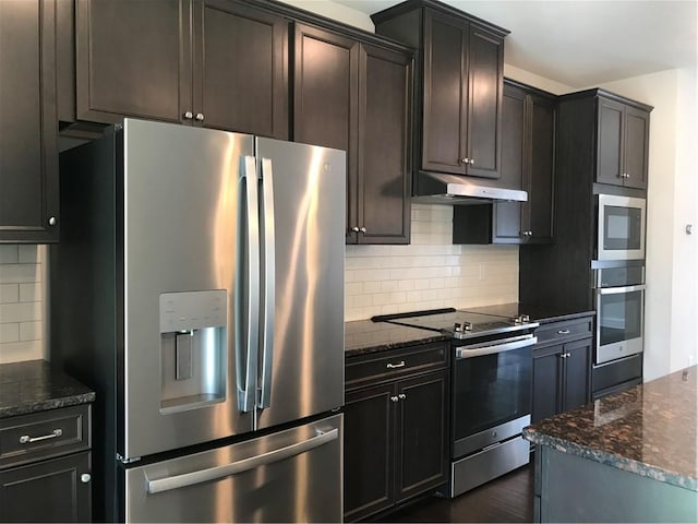 kitchen featuring decorative backsplash, appliances with stainless steel finishes, and dark stone countertops