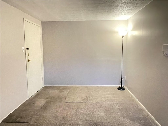 carpeted spare room with a textured ceiling