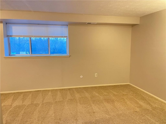 carpeted empty room featuring a textured ceiling