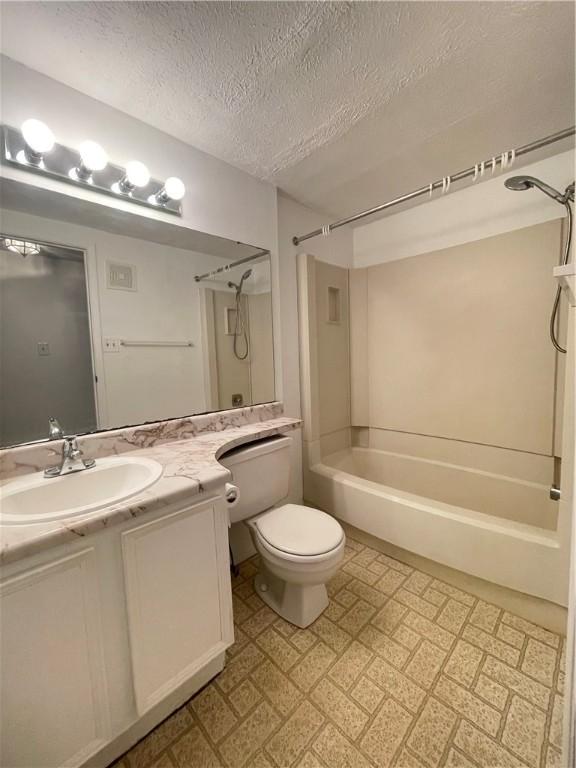 full bathroom featuring vanity, toilet, shower / tub combination, and a textured ceiling