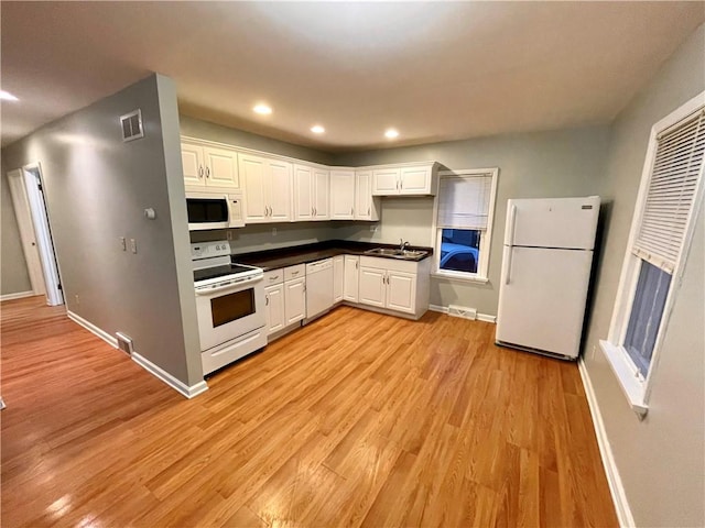 kitchen featuring white cabinets, white appliances, light hardwood / wood-style flooring, and sink