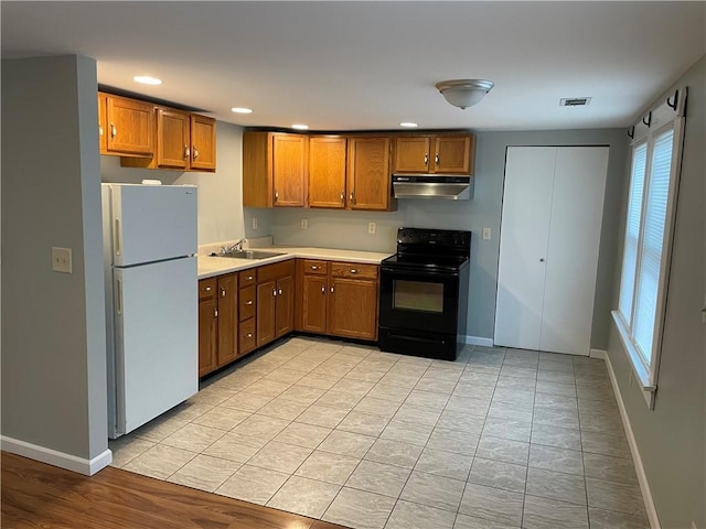 kitchen with plenty of natural light, white refrigerator, black range with electric stovetop, and sink