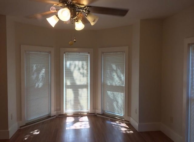 unfurnished room with ceiling fan and dark hardwood / wood-style flooring