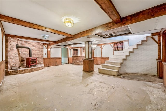 basement featuring a wood stove and brick wall