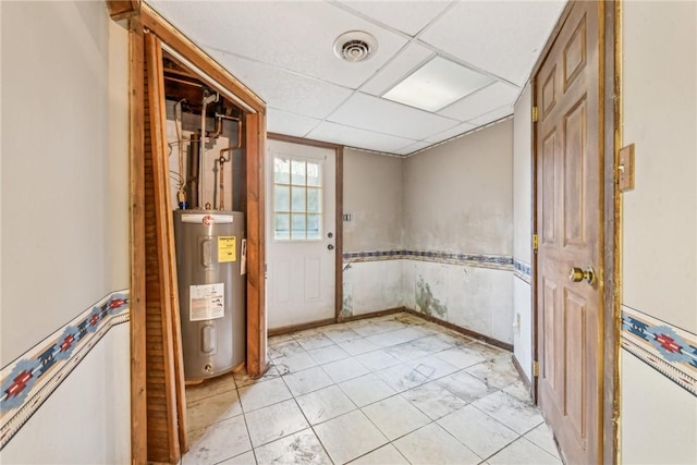 empty room with electric water heater and a paneled ceiling