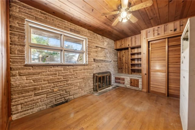 unfurnished living room with hardwood / wood-style floors, ceiling fan, and wooden ceiling