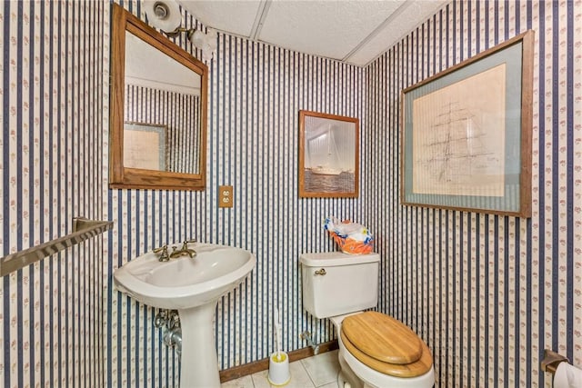 bathroom featuring tile patterned floors, a textured ceiling, and toilet