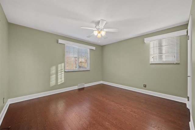 spare room featuring ceiling fan and dark wood-type flooring