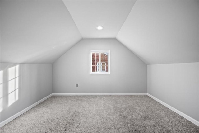 additional living space featuring carpet floors and vaulted ceiling