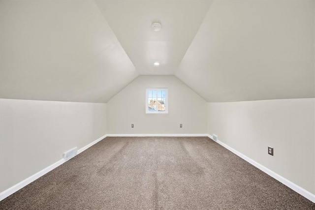 additional living space with carpet flooring and vaulted ceiling