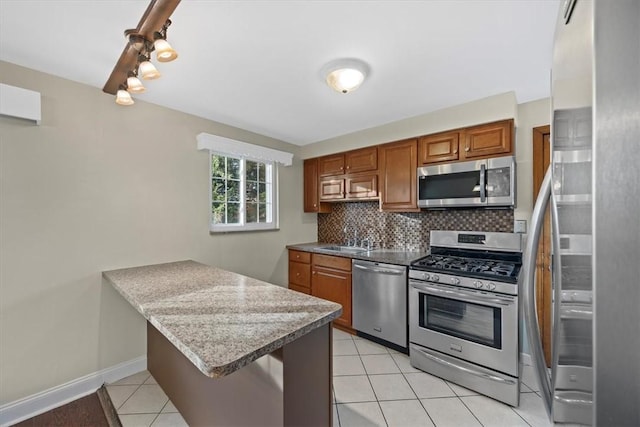 kitchen with decorative backsplash, a breakfast bar, stainless steel appliances, sink, and light tile patterned flooring