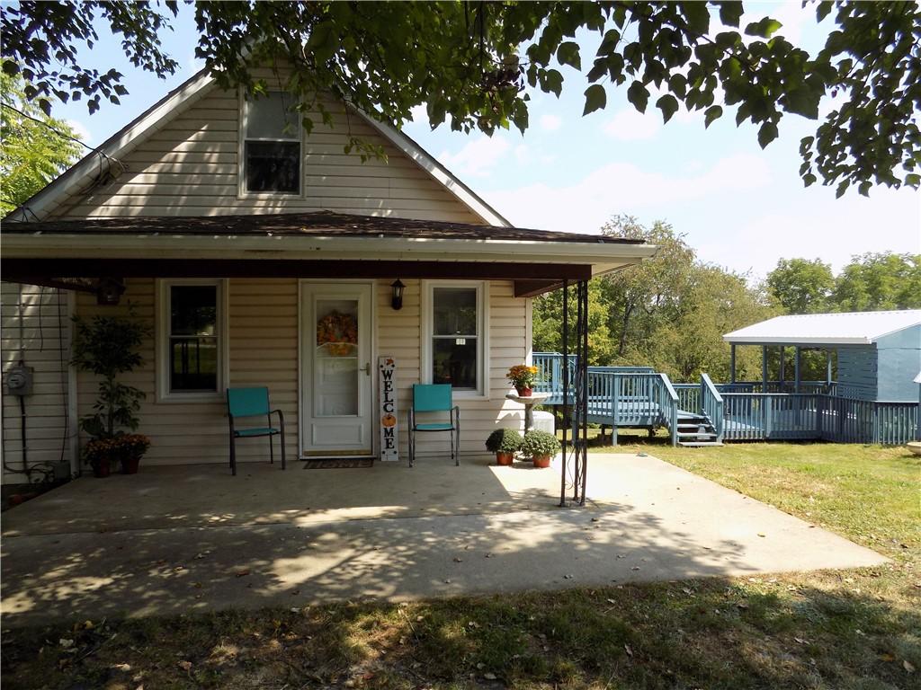 rear view of property featuring a yard and a porch