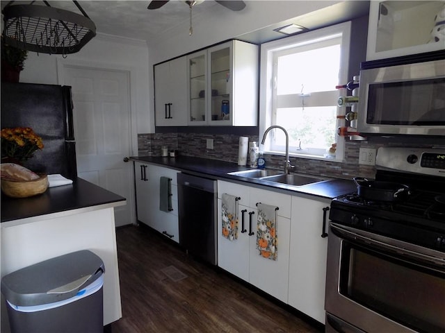 kitchen featuring dark wood-type flooring, white cabinets, sink, appliances with stainless steel finishes, and tasteful backsplash