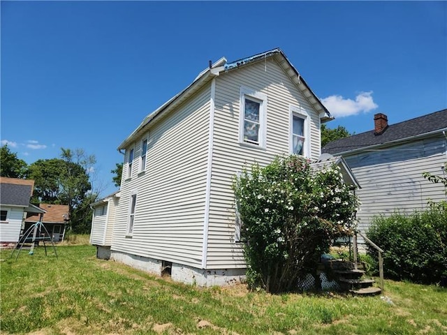 view of side of home with a yard