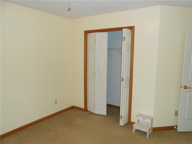 unfurnished bedroom with light carpet and a closet