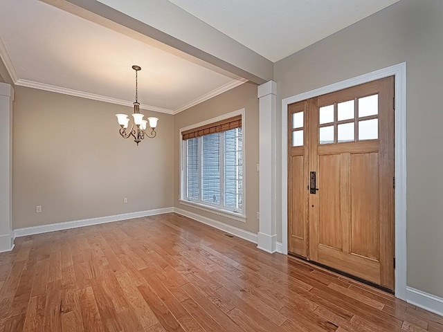 foyer featuring crown molding, hardwood / wood-style floors, and an inviting chandelier