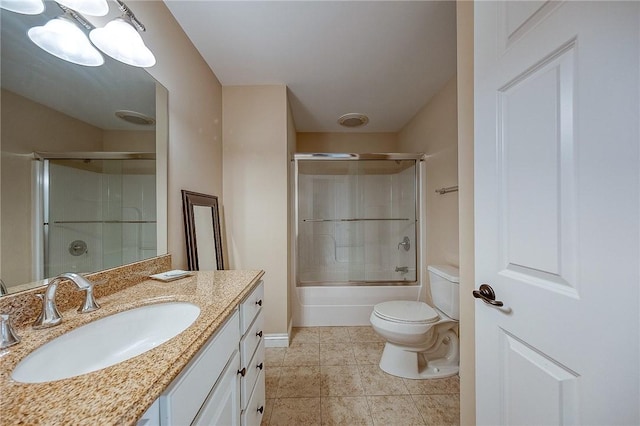 full bathroom with tile patterned floors, vanity, bath / shower combo with glass door, and toilet