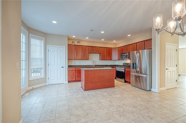 kitchen featuring a healthy amount of sunlight, a center island, light tile patterned flooring, and stainless steel appliances