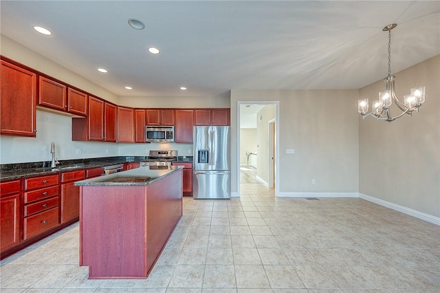 kitchen with appliances with stainless steel finishes, sink, pendant lighting, an inviting chandelier, and a center island