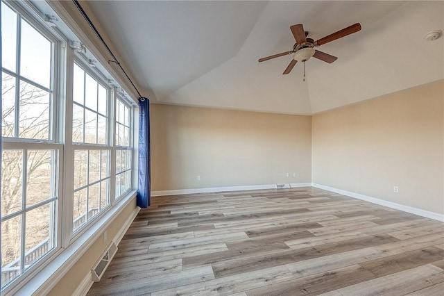 spare room with light hardwood / wood-style floors, vaulted ceiling, and a healthy amount of sunlight