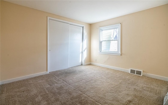 unfurnished bedroom with a closet and carpet floors