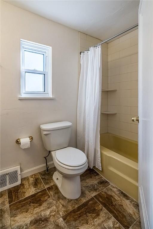 bathroom featuring shower / bathtub combination with curtain and toilet