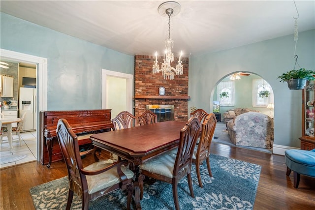 dining area featuring a notable chandelier, dark hardwood / wood-style floors, and a fireplace