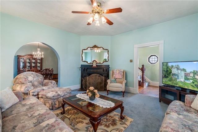 living room with carpet and ceiling fan with notable chandelier