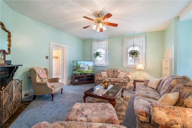 living room with ceiling fan and dark colored carpet