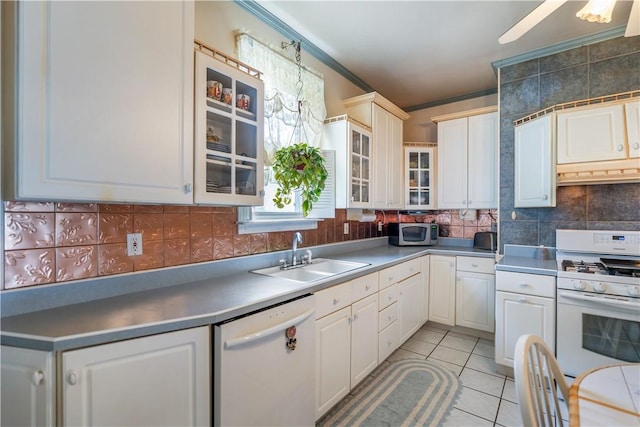 kitchen with white appliances, white cabinets, sink, light tile patterned floors, and ornamental molding