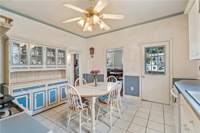 dining space featuring ceiling fan, ornamental molding, and light tile patterned flooring