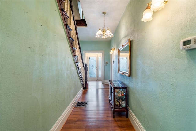 hallway featuring a chandelier and dark hardwood / wood-style floors