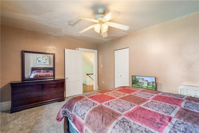 bedroom with ceiling fan, light colored carpet, and a closet