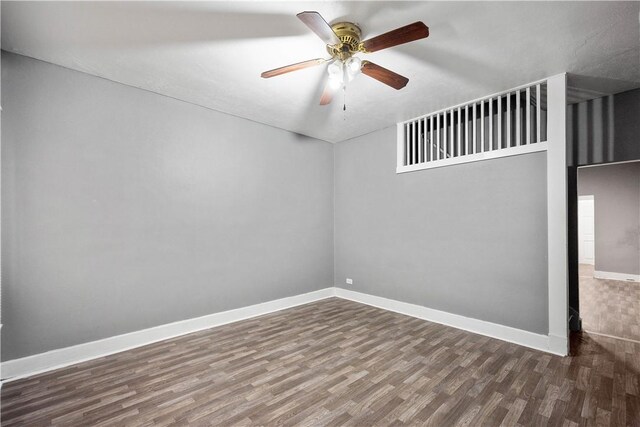 spare room featuring dark hardwood / wood-style flooring and ceiling fan