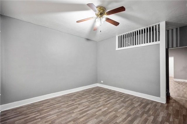 empty room with dark hardwood / wood-style flooring and ceiling fan