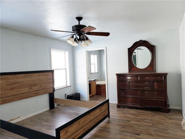 bedroom with dark hardwood / wood-style floors, ensuite bath, and ceiling fan