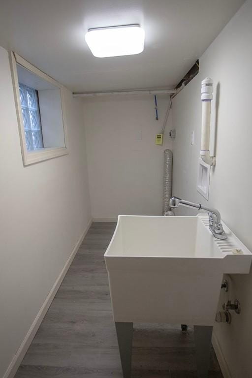 clothes washing area with dark hardwood / wood-style flooring