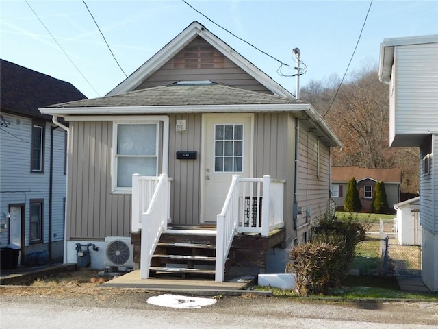 bungalow-style home with ac unit