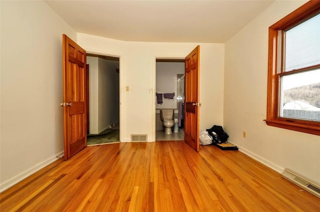 unfurnished bedroom featuring connected bathroom and light wood-type flooring