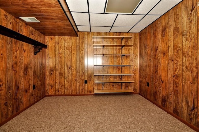 bonus room with carpet floors and wooden walls