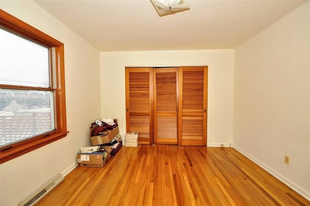 unfurnished bedroom with a closet and light hardwood / wood-style flooring