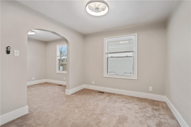 unfurnished room featuring light carpet