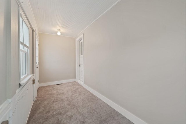 unfurnished room with light colored carpet and crown molding