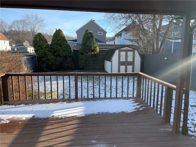 snow covered deck featuring a shed